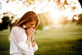 woman praying in field